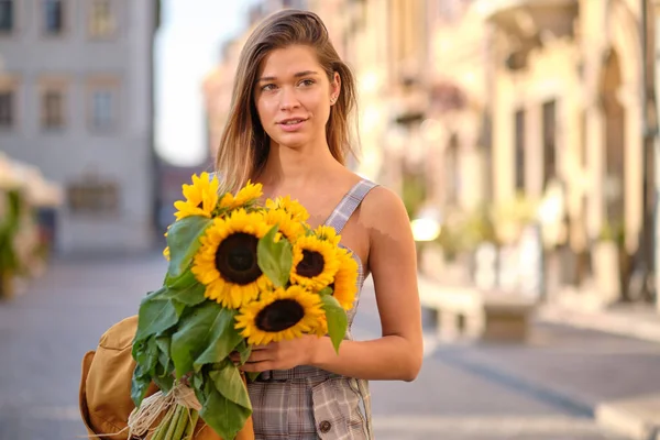 街中にひまわりの花束を持つ若いファッション女性 — ストック写真