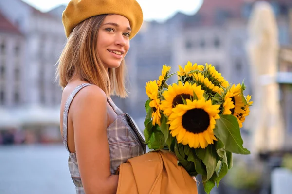 在城市里 年轻的时尚女性 戴着一束向日葵 — 图库照片