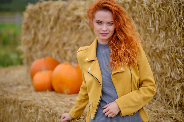 Autumn portrait of a beautiful woman with pumpkins