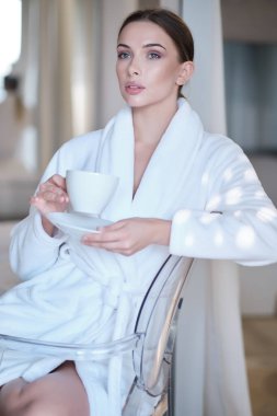 Evinde sabah kahvesi içen bir kadın.