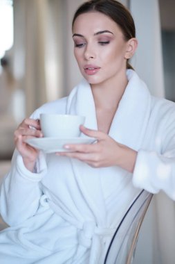 Evinde sabah kahvesi içen bir kadın.