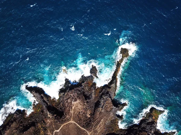 Top view of a deserted coast. Rocky shore of the island of Tenerife, Canary Islands, Spain. Aerial drone footage of sea waves reaching shore