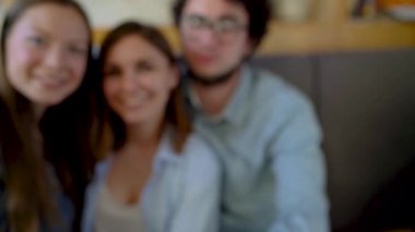 Üç arkadaş bir kafede oturup, iletişim iyi eğlenceler ve selfie yapmak. Ağır çekim