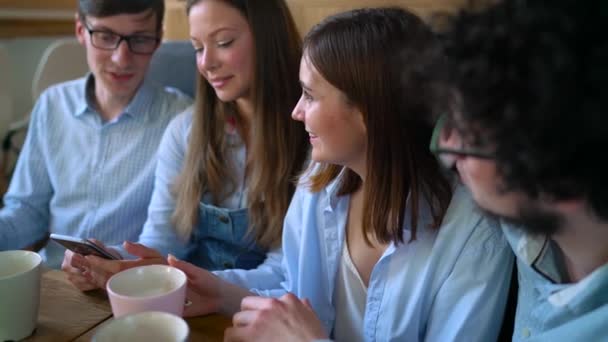 Young friends sit in a cafe, drink coffee and have fun communicating. Slow motion — Stock Video