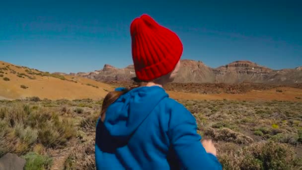 活跃的徒步旅行妇女徒步旅行在 Teide 国家公园并且在智能手机上做相片风景。在特内里费岛, 加那利群岛, 西班牙有背包的高加索年轻女子 — 图库视频影像