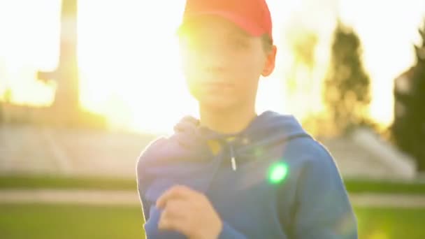 Vrouw loopt door het stadion bij zonsondergang — Stockvideo