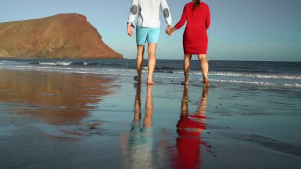 Coppia innamorata spensierata camminando verso l'acqua sulla spiaggia. Pittoresca costa oceanica di Tenerife, Isole Canarie, Spagna — Video Stock