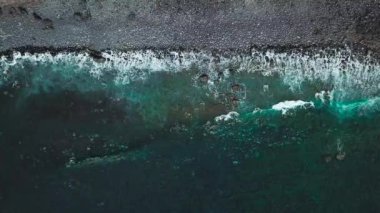 Üstten görünüm ıssız bir siyah volkanik Beach. Tenerife Island kıyıları. Dalgalar kıyıya ulaşan deniz hava dron görüntüleri