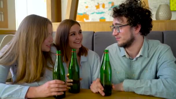 Három mosolygó meg ül egy kávézóban, vizet vagy sört inni és szórakozni, kommunikáció