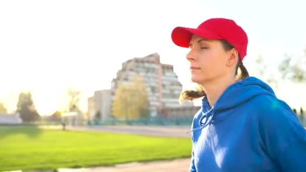 Mulher corre pelo estádio ao pôr-do-sol — Vídeo de Stock