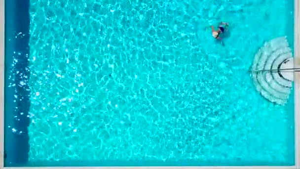 Vista de cima como uma mulher de fato de banho azul nada na piscina — Vídeo de Stock