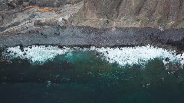 Vista superior de uma praia vulcânica negra deserta. Costa da ilha de Tenerife. Imagens aéreas de drones de ondas marinhas que chegam à costa — Vídeo de Stock