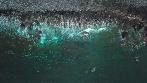 Вид сверху на черный вулканический пляж. Берег острова Тенерифе. Запись с воздушного беспилотника морских волн, достигших берега — стоковое видео