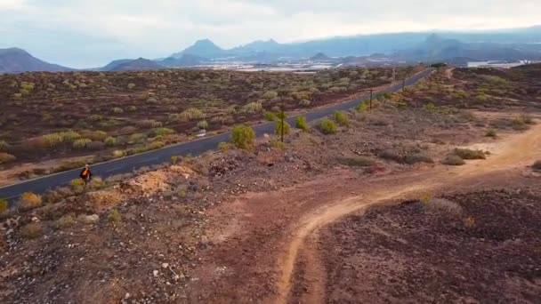 Повітряний вид на велосипедиста, який подорожує пустельною дорогою — стокове відео
