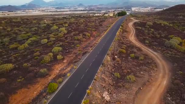 Вид сверху на автомобиль, едущий по пустынной дороге — стоковое видео