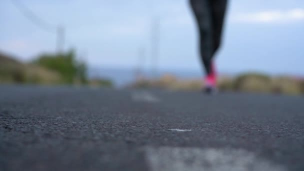 Laufschuhe - Frau bindet Schnürsenkel auf einer Wüstenstraße in einer bergigen Gegend. Zeitlupe — Stockvideo