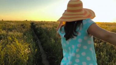 Peşimden - sarı şapkalı adamlar el çekerek mutlu genç kadın. El ele yürüyüş yeşil buğday tarlası batımında at. Ağır çekim