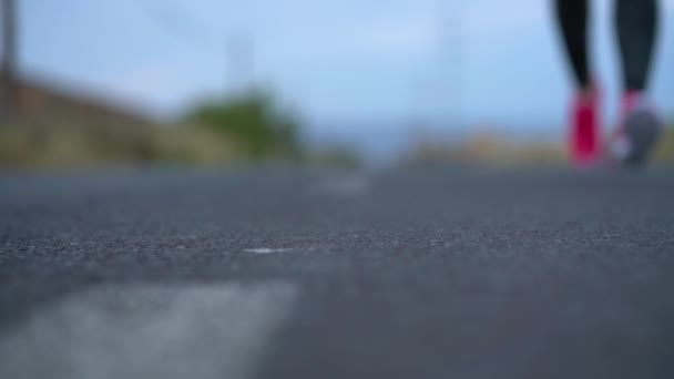 Sapatos de corrida - mulher que ata cadarços de sapato em uma estrada de deserto em uma área montanhosa. Movimento lento — Vídeo de Stock