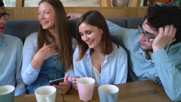 Junge Freunde sitzen in einem Café, trinken Kaffee und haben Spaß an der Kommunikation. Zeitlupe — Stockvideo