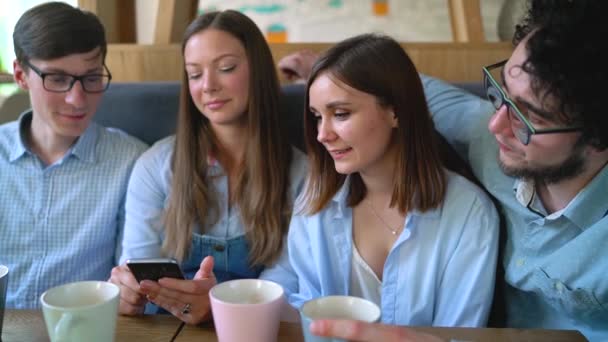 Unga vänner sitta på ett café, dricka kaffe och ha kul kommunicera. Slow motion — Stockvideo