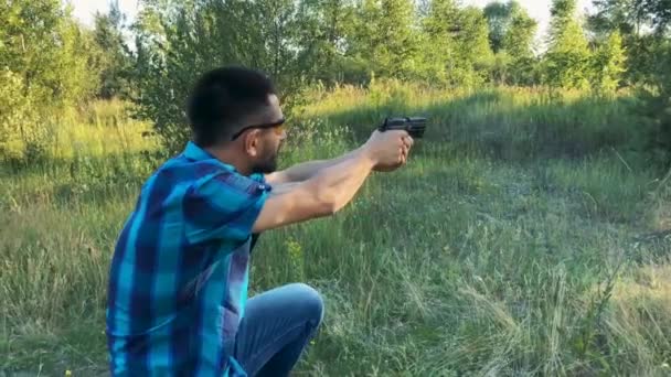 Young man is shooting from a gun, close up. Slow motion — Stock Video