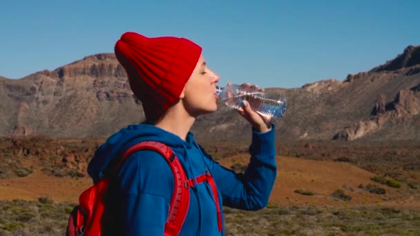 Wandelen vrouw drinkwater na wandeling op de Teide, Tenerife. Kaukasische vrouwelijke toeristische op Tenerife, Canarische eilanden. Slow motion — Stockvideo