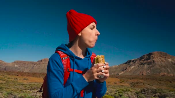 Vandring kvinna äter smörgås efter vandringen på Teide, Teneriffa. Kaukasiska kvinnlig turist på Teneriffa, Kanarieöarna — Stockvideo