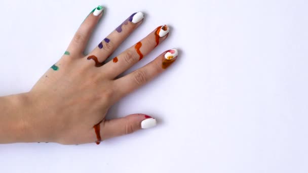 Творческая концепция - мужчина и женщина делают отпечатки своих раскрашенных рук на белом фоне — стоковое видео