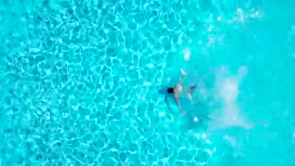 Vista desde arriba mientras un hombre salta y se sumerge en la piscina y nada bajo el agua — Vídeos de Stock