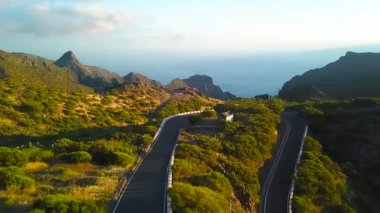 Dolambaçlı yol ve günbatımı, Tenerife, Kanarya Adaları, İspanya, Masca mesafe okyanusta kayalar, yükseklikten görüntülemek.