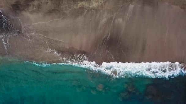 Blick von oben auf einen einsamen schwarzen Vulkanstrand. Küste der Insel Teneriffa. Drohnenaufnahmen von Meereswellen, die die Küste erreichen — Stockvideo