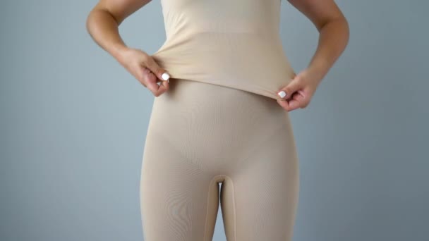 Kvinnan döljer ofullkomlighet i figuren under dragande korrigerande underkläder. Begreppet aspiration för en perfekt kropp — Stockvideo