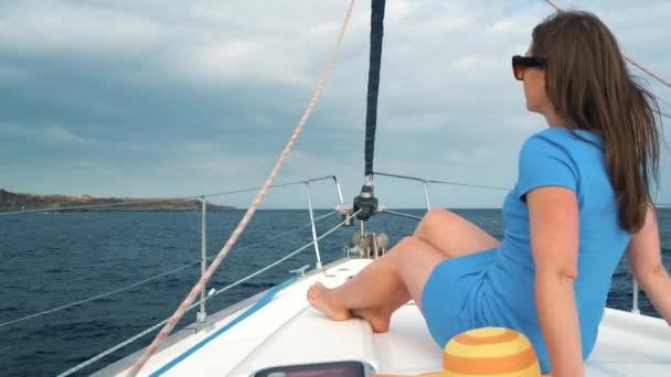 Femme dans un chapeau jaune et robe bleue fille repose à bord d'un yacht près du phare sur la saison estivale à l'océan — Video