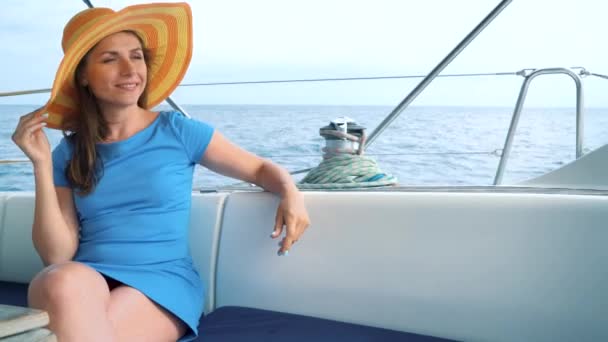 Žena ve žlutém klobouku a modré šaty dívka spočívá na palubě jachty na letní sezónu v oceánu — Stock video