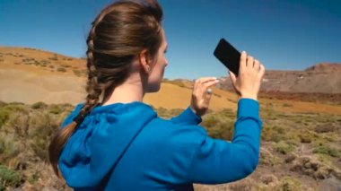 Teide Milli Parkı üzerinde hiking etkin uzun yürüyüşe çıkan kimse kadın ve fotoğraf manzara smartphone üzerinde yapar. Tenerife, Kanarya Adaları, İspanya