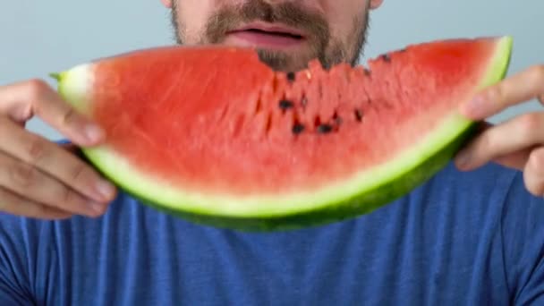 Bärtiger Mann isst eine saftige Wassermelone — Stockvideo