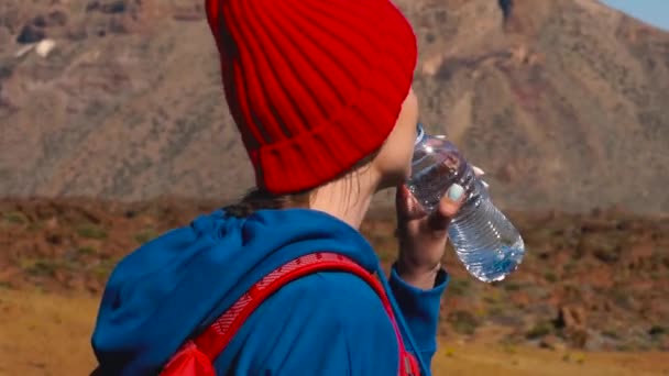 Пешая женщина пьет воду после прогулки по Тейде, Тенерифе. Кавказская туристка на Тенерифе, Канарские острова — стоковое видео