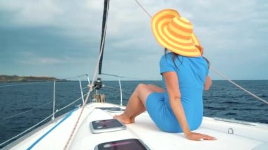 Lüks hayat kavramı. Sarı şapka ve mavi elbiseli bir kadın portresi gemiye lighthouse yakınındaki bir yat yaz sezonu ocean adlı aittir.