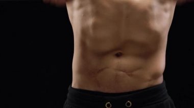 Adam bir halter alıştırmalar stüdyoda siyah bir zemin üzerine eğitim yapıyor