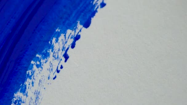 Dibujo con pincel sobre papel blanco con pintura acrílica azul de cerca — Vídeos de Stock