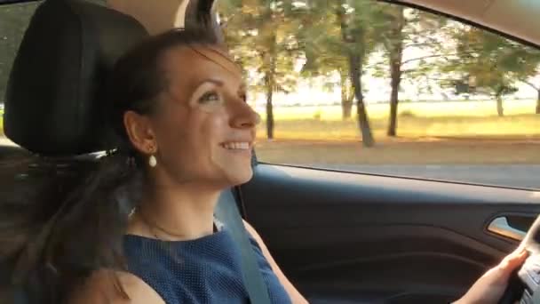 Vrolijke vrouw rijden van een auto, het prachtige landschap en de zonsondergang buiten — Stockvideo