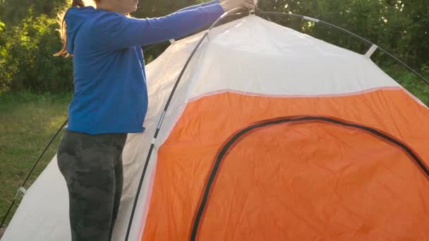 Kvinnan är att sätta en turist tält i skogen — Stockvideo