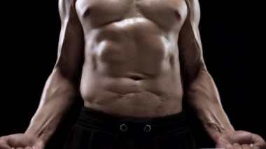 Adam bir halter alıştırmalar stüdyoda siyah bir zemin üzerine eğitim yapıyor