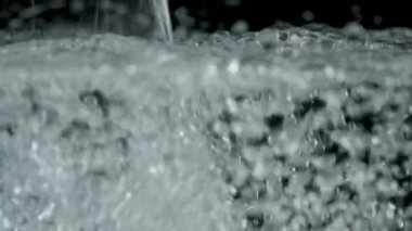 Yüzeye yükselen siyah arka plan üzerinde kabarcıklar. Ağır çekim