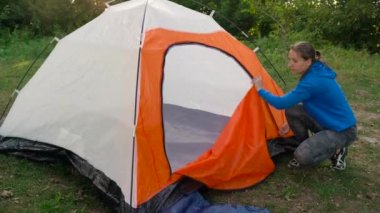 Kadın ormanda bir turist çadır koyuyor