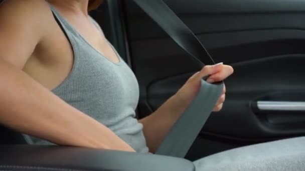 Frau schnallt Sicherheitsgurt im Auto an, während sie vor der Fahrt im Fahrzeug sitzt — Stockvideo