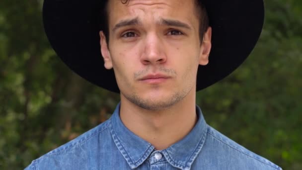 Jovem hipster homem de chapéu rindo, relaxado na frente da câmera — Vídeo de Stock