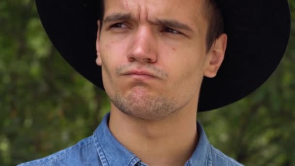 Jovem hipster homem de chapéu rindo, relaxado na frente da câmera — Vídeo de Stock