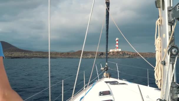 Kadın sarı hat ve mavi elbise yaz sezonu gemiye bir yat lighthouse yakınındaki ocean adlı aittir — Stok video