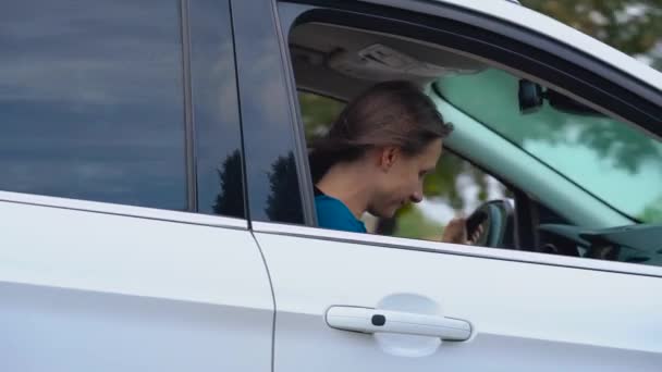 Deux jeunes femmes montent dans une voiture et s'amusent. L'un d'eux prend une photo de lui-même sur une caméra — Video